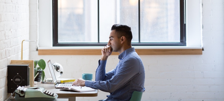 Man reading on his laptop about how to relocate your business