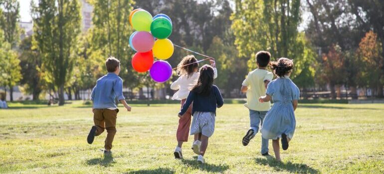 Kids running with balloons in the park