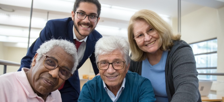 Group of senior citizens and a younger man smiling